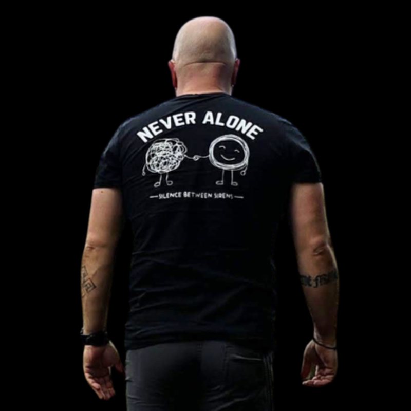 Man wearing the black Silence Between Sirens Never Alone T-shirt, seen from behind
